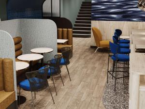 un restaurant avec des tables, des chaises et des chaises bleues dans l'établissement Mercure Annecy Centre, à Annecy