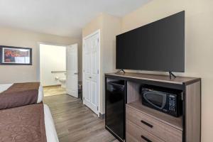 a hotel room with a flat screen tv on a entertainment center at Best Western Brenham in Brenham