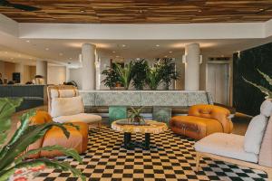 a lobby with orange chairs and a coffee table at Wayfinder Waikiki in Honolulu