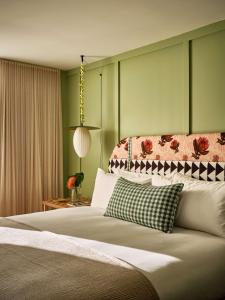 ein Schlafzimmer mit einem großen Bett und grünen Wänden in der Unterkunft Wayfinder Waikiki in Honolulu