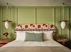 ホノルルにあるWayfinder Waikikiのベッドルーム1室(花のヘッドボード付きのベッド1台付)