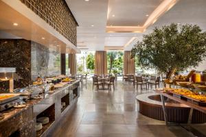 um restaurante com uma linha de buffet com mesas e cadeiras em Radisson Hotel Muscat Panorama em Mascate