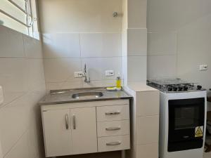 a small kitchen with a sink and a stove at Inspire GuestHouse in Campos do Jordão +62 photos
