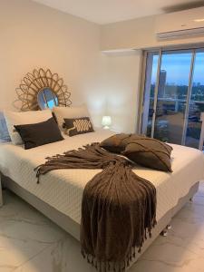 a bedroom with a large bed with a large window at Appartamento Long Beach in Punta del Este