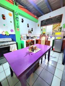 a purple table in front of a kitchen with a counter at Hostal Leyendas in León