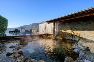 ein Wasserpool neben einem Gebäude in der Unterkunft 阿蘇CANYON TERRACE＆LODGE in Kurokawa Onsen