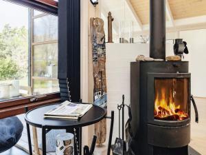 スケーエンにある6 person holiday home in Skagenの暖炉付きのリビングルーム(テーブル、コンロ付)