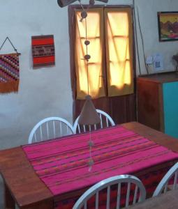 mesa de comedor con mantel rosa en La bodeguita-casa rural en Chilecito