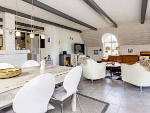 JerupにあるThree-Bedroom Holiday home in Børkop 17のリビングルーム(木製テーブル、白い椅子付)
