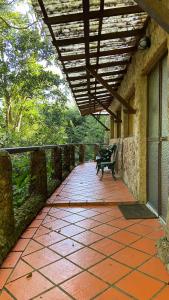 a bench sitting on a walkway next to a building at Chalé Laranja - Sítio Caldeirão in Posse