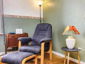 a living room with a chair and a lamp at 5 person holiday home in L s in Læsø
