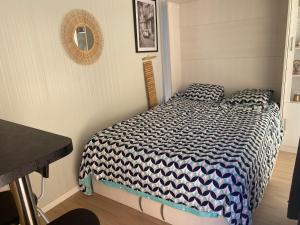 Un dormitorio con una cama con un edredón azul y blanco. en Escale Tiny House Zen, en Riom