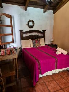 - une chambre avec un grand lit et une couverture rouge dans l'établissement Hotel Casa Sofia, à Antigua Guatemala