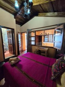 a bedroom with a large bed with a purple blanket at Hotel Casa Sofia in Antigua Guatemala