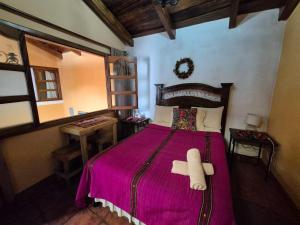 a bedroom with a bed with a teddy bear on it at Hotel Casa Sofia in Antigua Guatemala