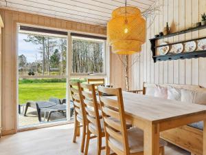 Ålbækにある7 person holiday home in lb kのダイニングルーム(木製テーブル、椅子付)
