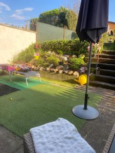 a patio with an umbrella and a blanket at Apartmán K Lomu 960 in Starý Plzenec