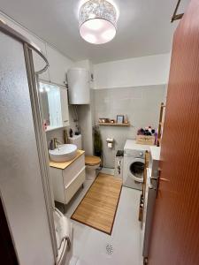 a bathroom with a sink and a washing machine at Sara Brela Apartment in Brela
