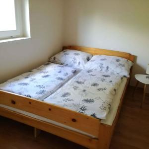 ein Bett mit einem Holzrahmen in einem Zimmer in der Unterkunft Holiday Homes in Balatonmariafürdo 48114 in Balatonmáriafürdő