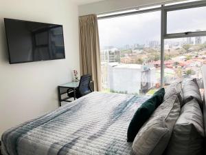 a bedroom with a bed and a large window at CityScape Properties 2br AC 754 ft2 Amenities 24 hours Concierge in San José +32 photos