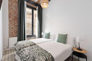 a bedroom with a white bed and a window at Poble Sec Charming Apartment in Barcelona