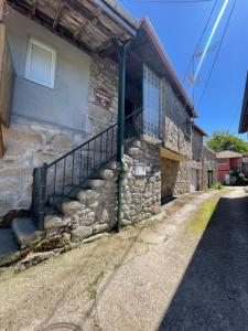 un edificio in pietra con una scala sul lato di Casa rural Herminia a Ourense