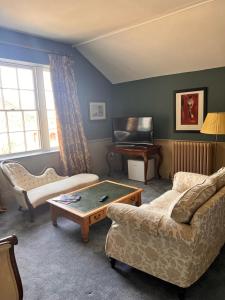 a living room with a couch and a table at Llanerchydol Hall Suites in Welshpool