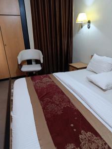 ein Hotelzimmer mit einem Bett und einem Stuhl in der Unterkunft Cozyworld Hotel in Ikeja