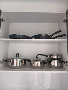 four pots and pans on a shelf in a kitchen at Apartamento cerca del Pilar in Zaragoza +10 photos