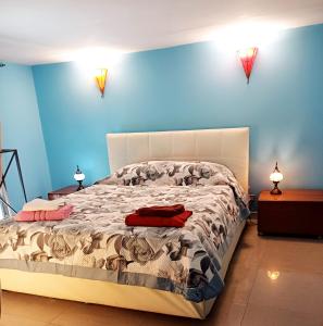 a bedroom with a large bed with blue walls at GoldenCube Guest House in Naples