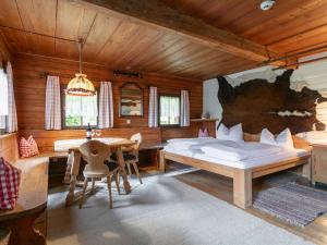 - une chambre avec un lit, une table et des chaises dans l'établissement Alpin Hideaway L, à Wörgl