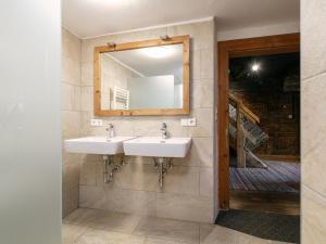 La salle de bains est pourvue de 2 lavabos et d'un miroir. dans l'établissement Alpin Hideaway L, à Wörgl