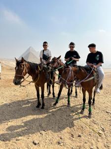 Tres hombres montando caballos delante de las pirámides en Studio Merit Pyramids View, en El Cairo