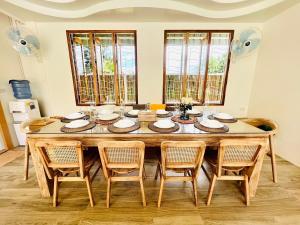 a dining room with a wooden table and chairs at Villa De Phawa in Samut Songkhram