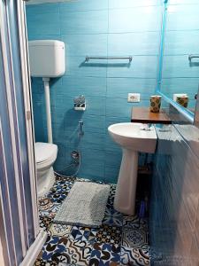 a blue bathroom with a toilet and a sink at GoldenCube Guest House in Naples