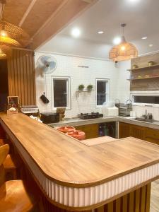 a large kitchen with a wooden counter top at Villa De Phawa in Samut Songkhram