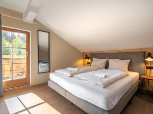 a bedroom with a large white bed and a window at Chalet Sonnenalp in Hopfgarten im Brixental
