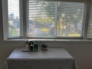 a table with a coffee maker on it in front of a window at Beautiful Home in Burnaby (Metrotown Area) in Burnaby