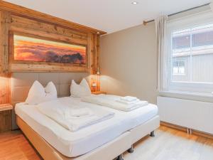 ein weißes Bett in einem Zimmer mit Fenster in der Unterkunft Schönfeld I in Kitzbühel