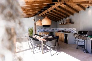 a kitchen with a table and chairs and a stove at GALVÃO HOUSE EXPERIENCE in Ribeira Brava