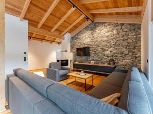 a living room with a blue couch and a stone wall at Luxury Sankt Lorenzen in Sankt Lorenzen ob Murau