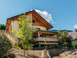 a log house with a balcony and a tree at Vesna S Home in Öblarn