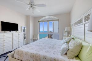 Schlafzimmer mit einem Bett, einem TV und einem Fenster in der Unterkunft 2 BR Monthly beach condo Miami in Hallandale Beach