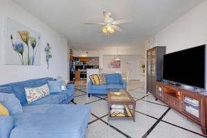 ein Wohnzimmer mit blauen Sofas und einem Flachbild-TV in der Unterkunft 2 BR Monthly beach condo Miami in Hallandale Beach