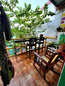 een patio met een tafel, stoelen en bomen bij Hostal Leyendas in León