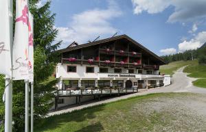 ein Gebäude mit einem Balkon mit Blumen darauf in der Unterkunft Appartementhaus Sonnenhang in Ehrwald