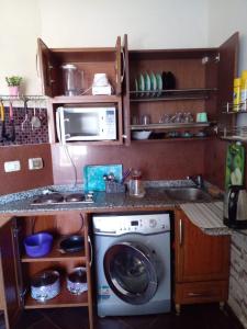 a kitchen with a washing machine and a microwave at Porto Matruh - Your Family's Peaceful Summer Stay in Marsa Matruh