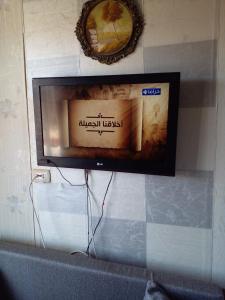 TV de pantalla plana colgada en la pared en Porto Matruh - Your Family's Peaceful Summer Stay, en Marsa Matruh