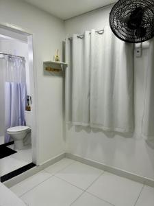 a bathroom with a shower curtain and a toilet at Âncora Suítes Arraial do Cabo in Arraial do Cabo +60 photos
