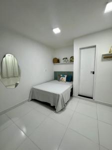 een slaapkamer met een bed in een witte kamer bij Âncora Suítes Arraial do Cabo in Arraial do Cabo